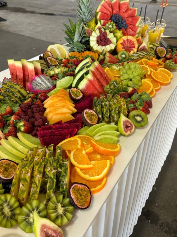 Fruit grazing table with watermelon, passionfruit, oranges, dragon fruit and kiwi