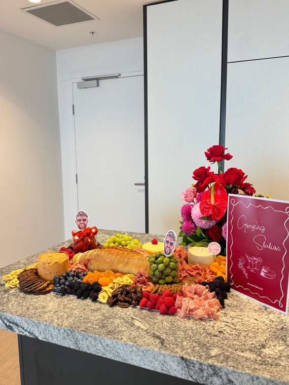 Savoury grazing table with cheeses, cured meats and flowers at a party
