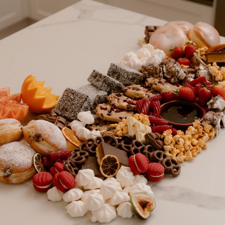 Dessert grazing table with donuts, lamingtons, macarons, meringues and chocolate